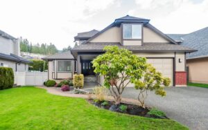 Suburban single family house with manicured lawn, front garden, and garage