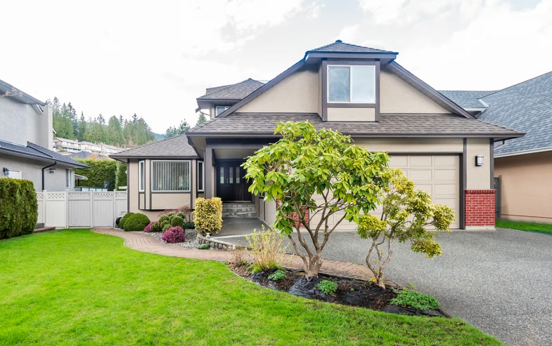 Suburban single family house with manicured lawn, front garden, and garage